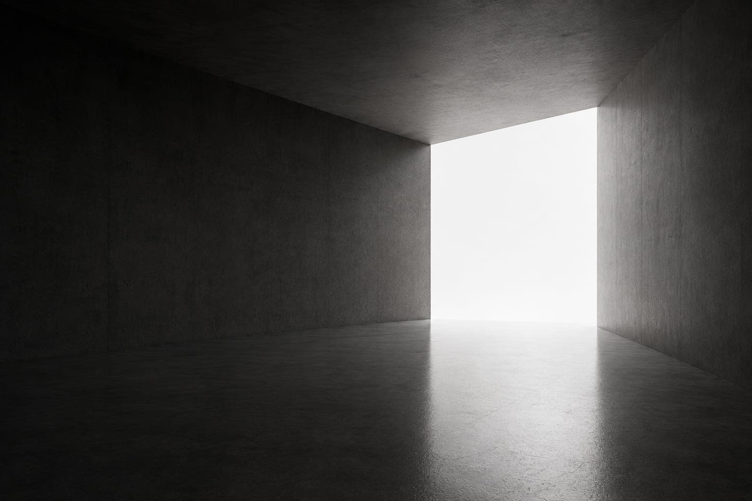 Dark concrete interior opening onto a doorway of bright light